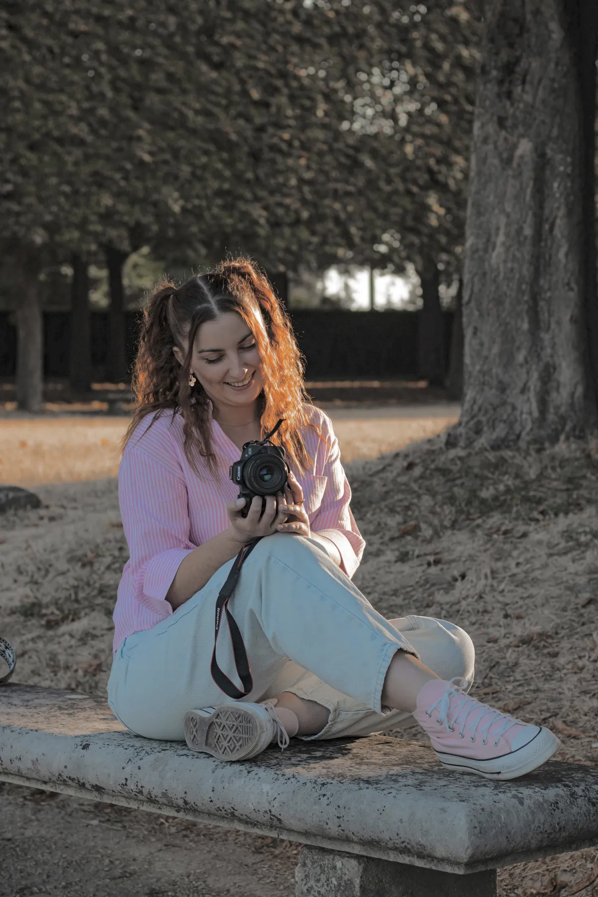Marion assise sur un banc, son appareil photo en main