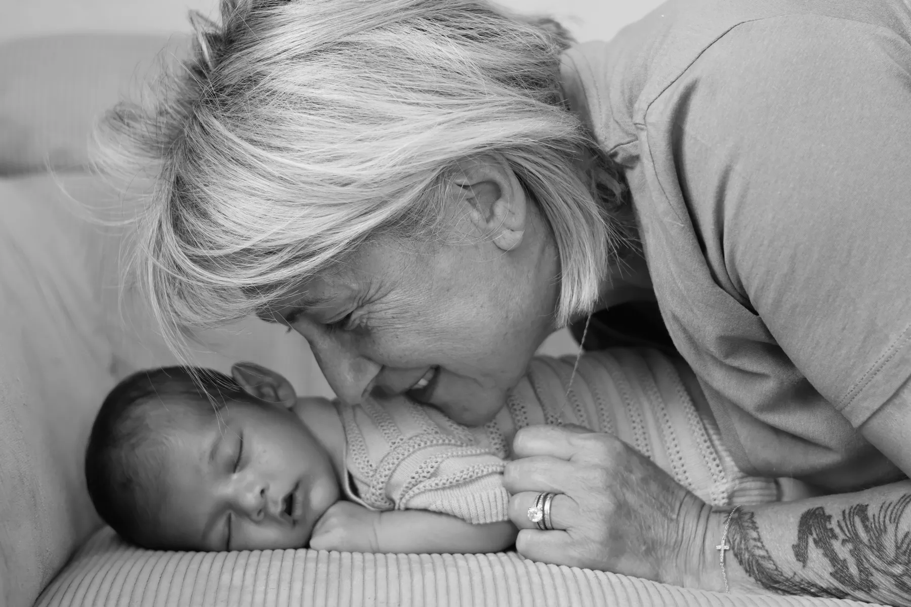 Une grand-mère embrasse tendrement un nouveau-né, en noir et blanc
