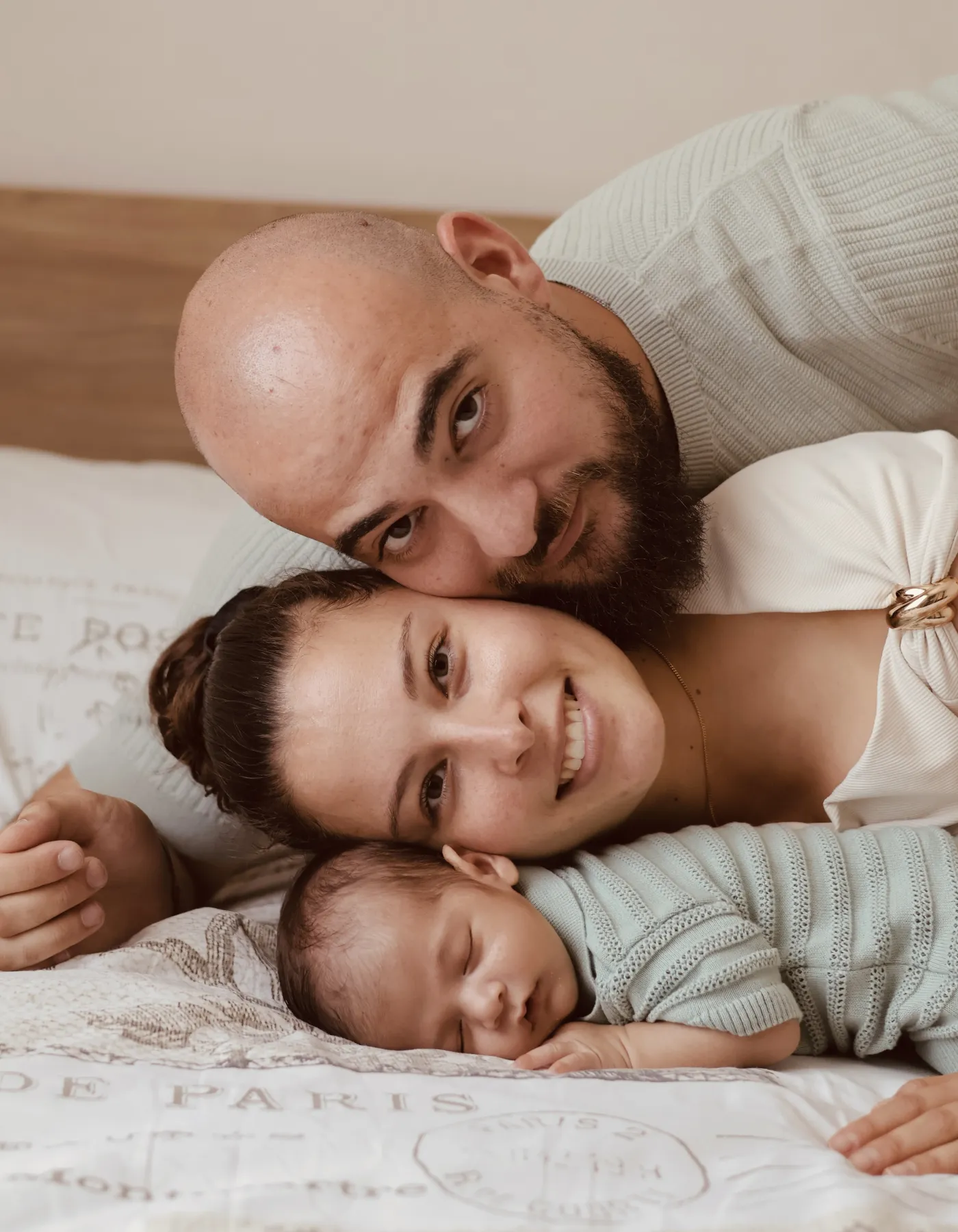 Parents souriants allongés tête contre tête avec leur nouveau-né
