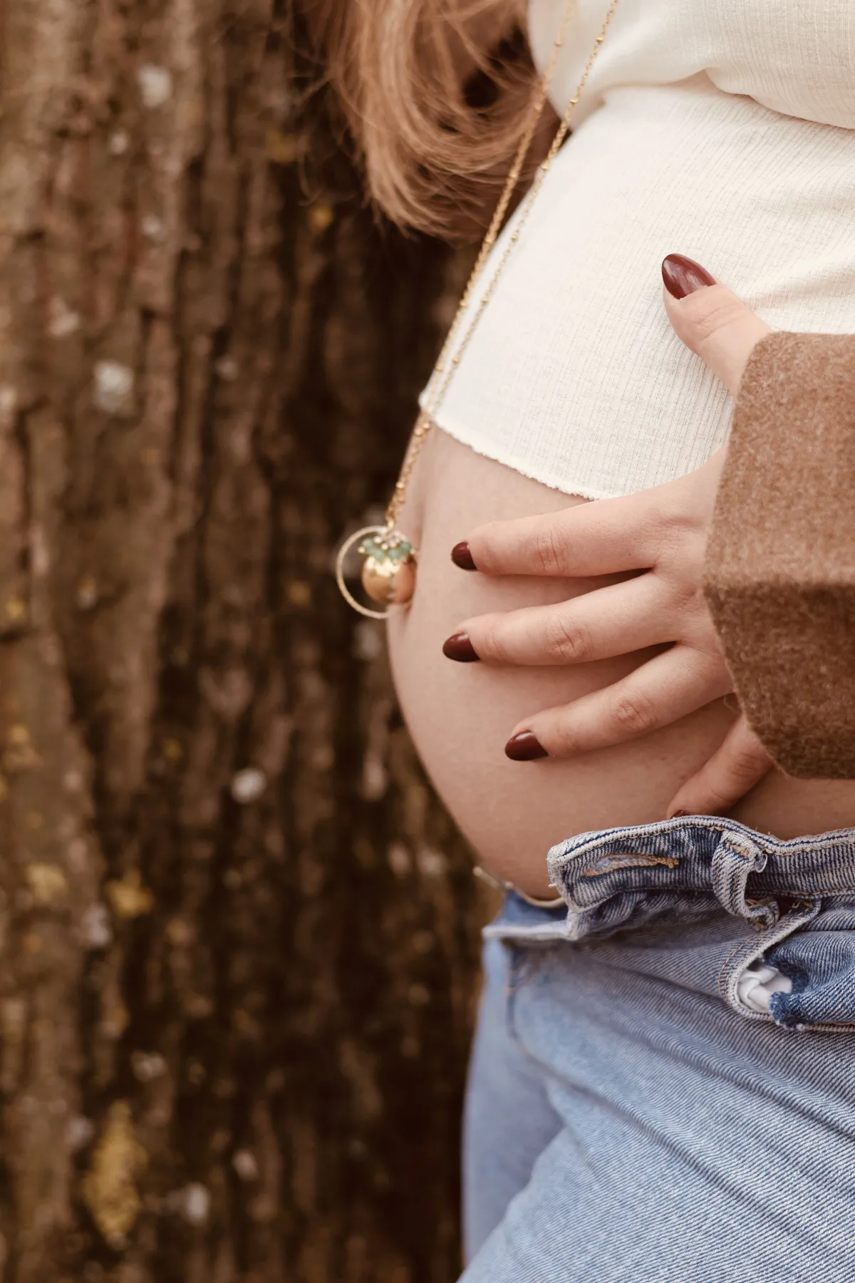 Les mains d'une future maman sur son ventre orné d'un bola