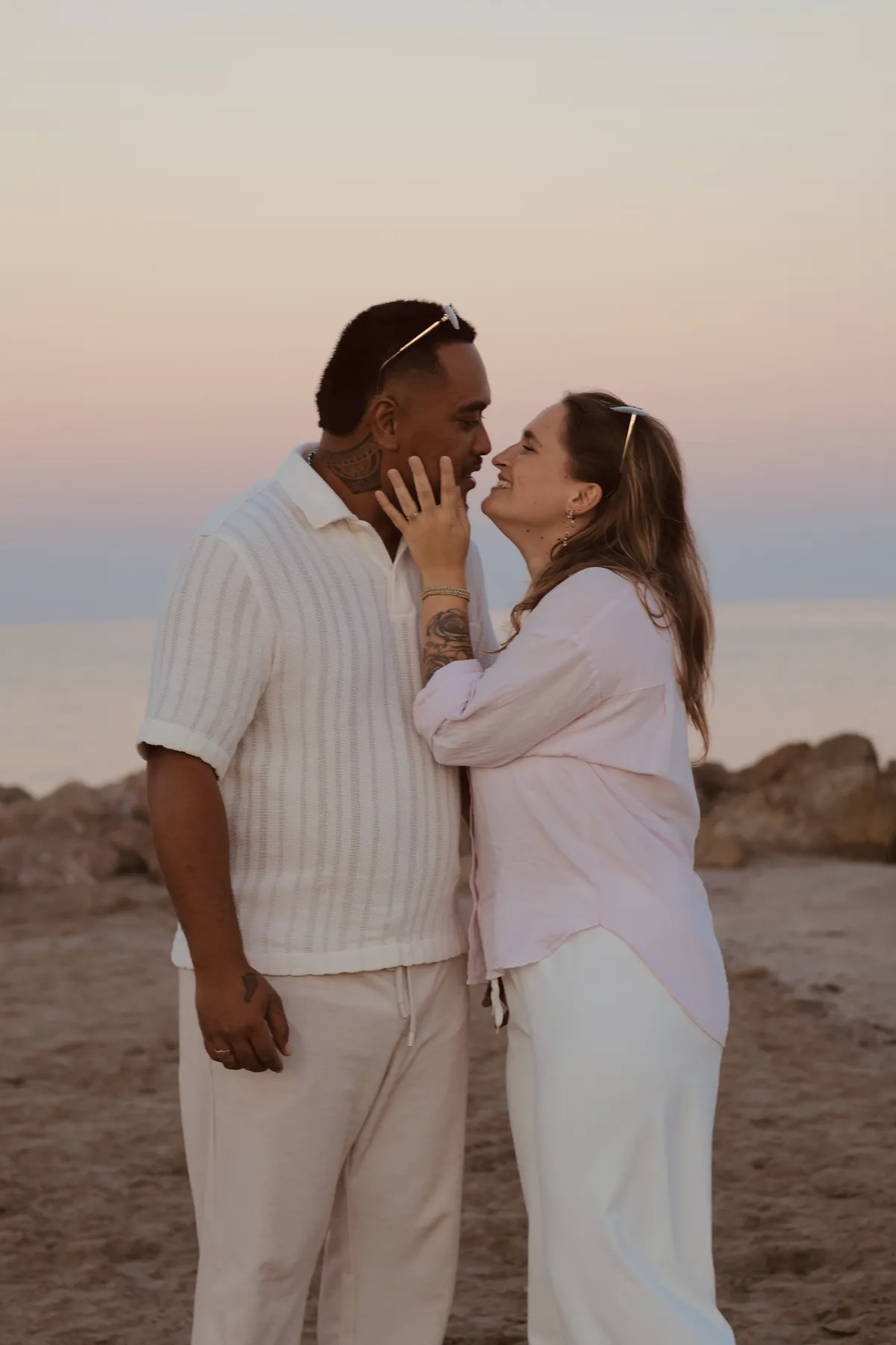 Un couple s'embrasse au bord de la mer au coucher du soleil